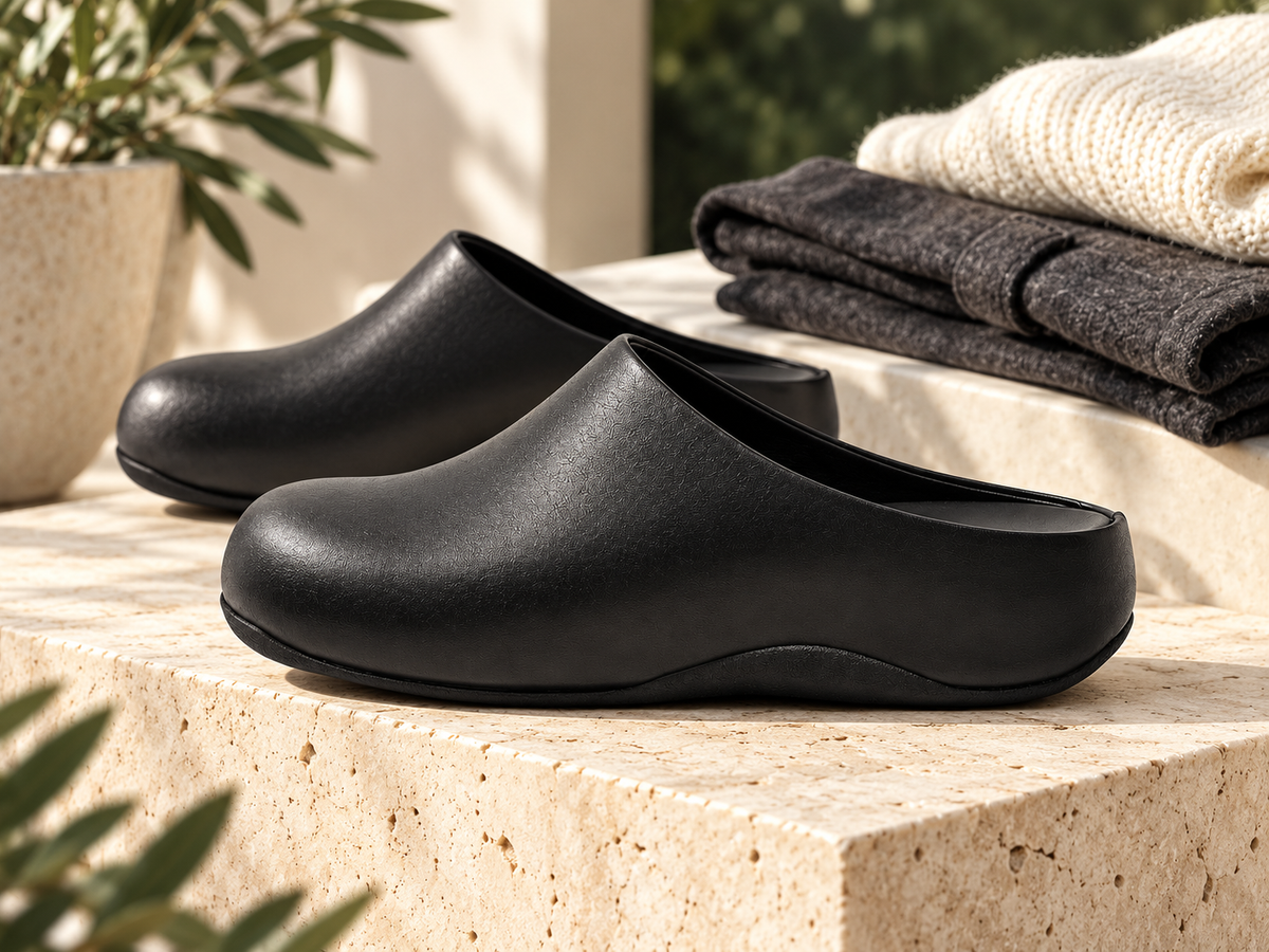 Black leather clogs with an ivory knit and charcoal trousers